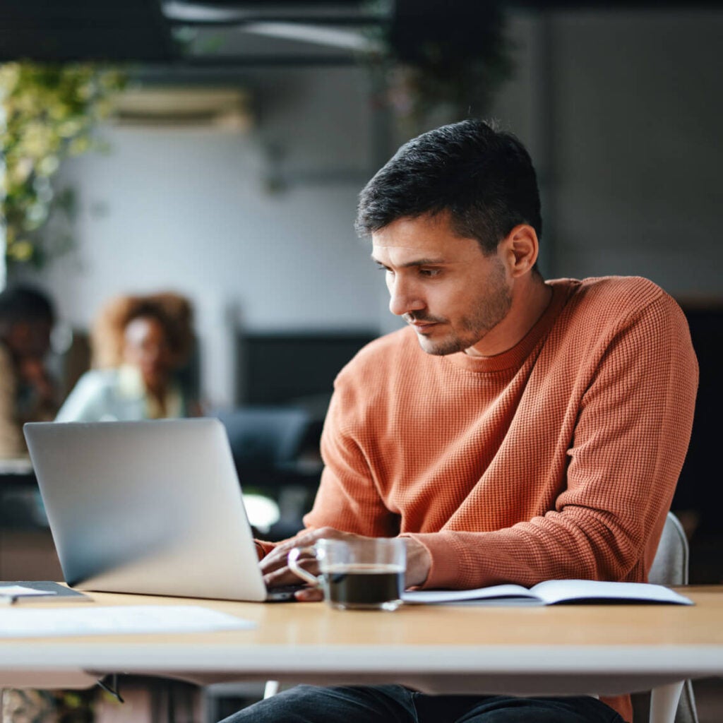 Man sitting at desk with laptop